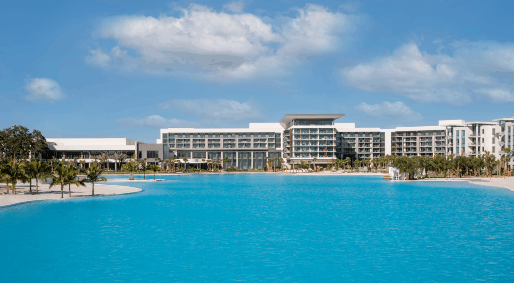 Aerial view of the Orlando Exchange Events venue with a large crystal-blue lagoon and modern resort buildings.