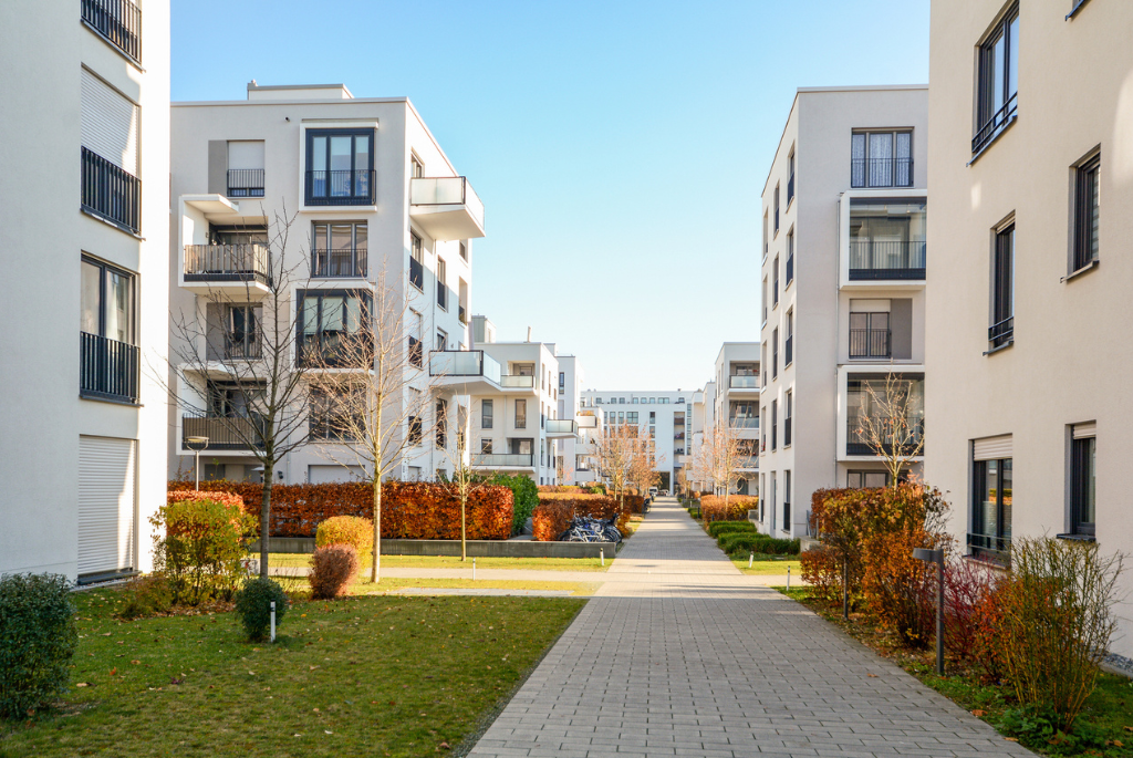 Multifamily apartment buildings with landscaped walkways designed to reduce urban heat and improve outdoor comfort.