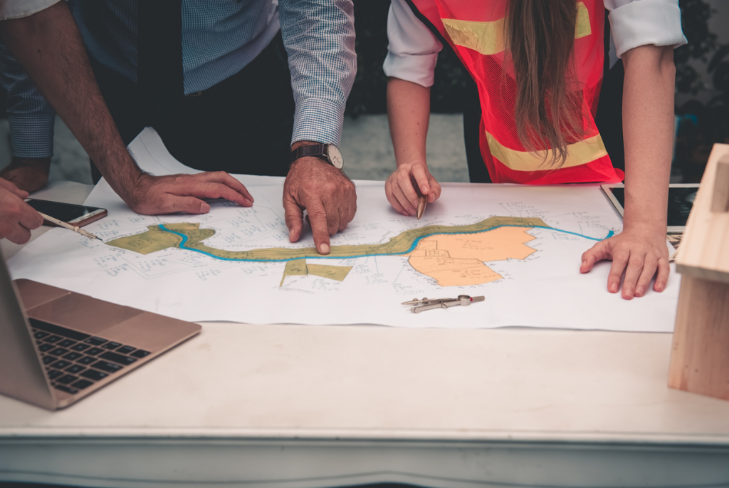 Builders reviewing site plans and land data together to evaluate potential lots using data-driven and AI-supported site selection methods.