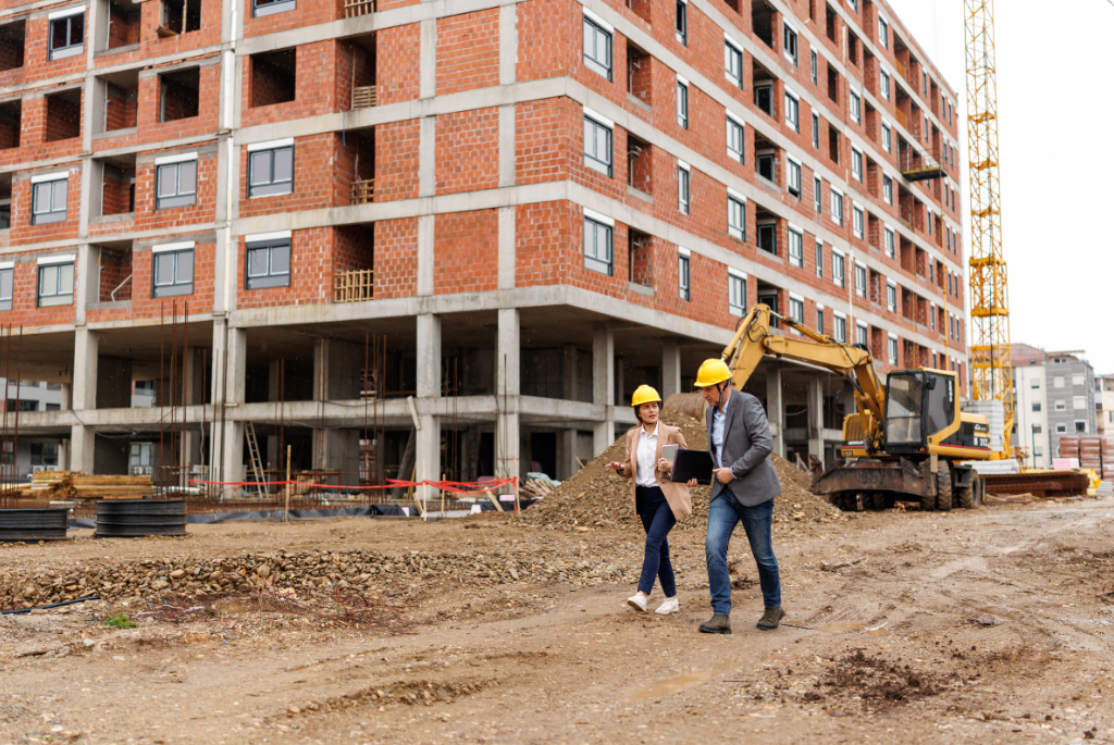 Construction managers walking through a large multifamily development site during active apartment building inspections.