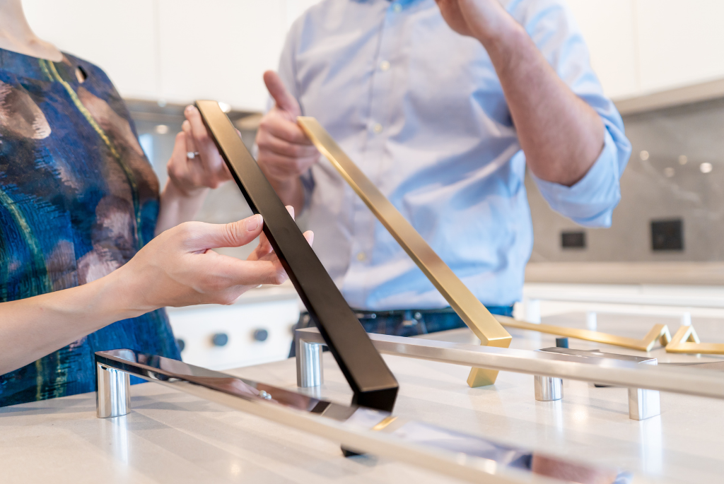 Homebuyers reviewing cabinet hardware and finish options at a residential design center.