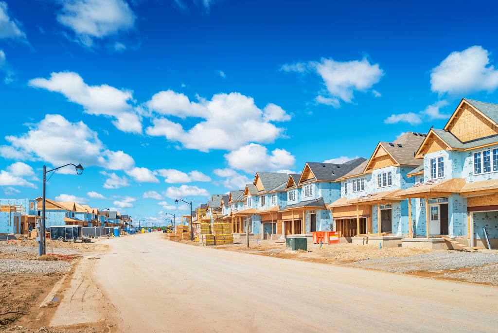 New residential homes under construction in a large suburban housing development.