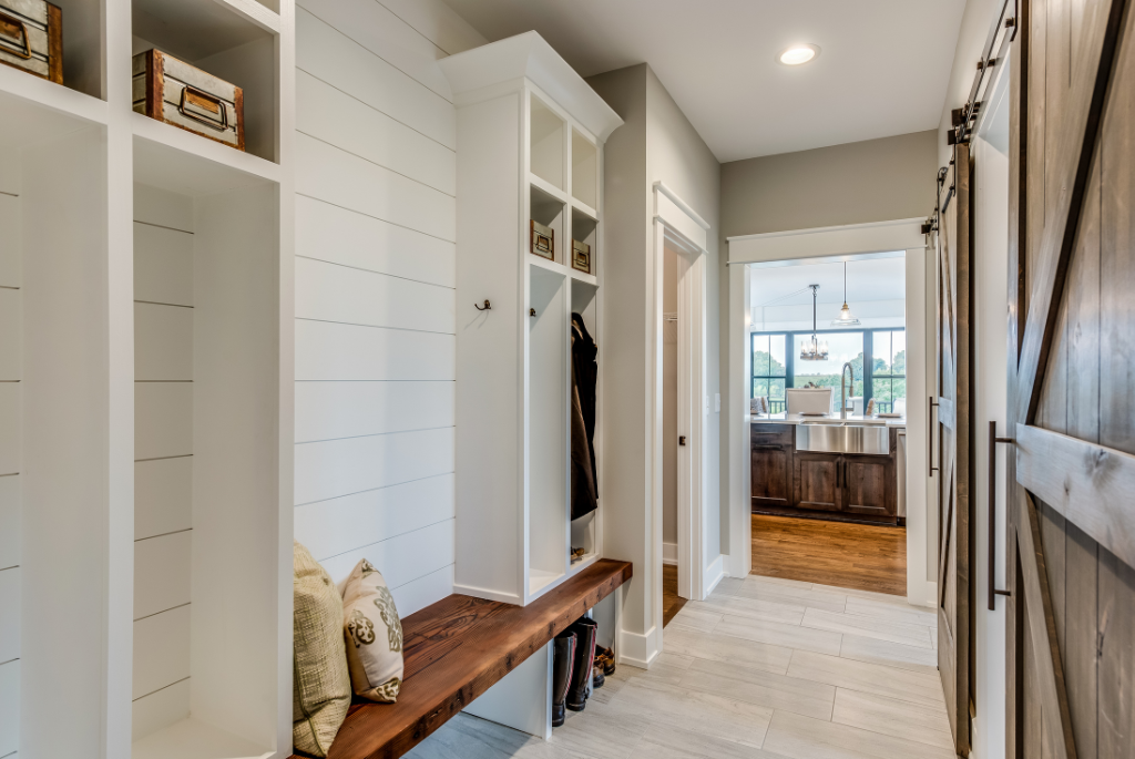 Built-in mudroom storage with shiplap walls, cubbies and bench in a single-family home entryway